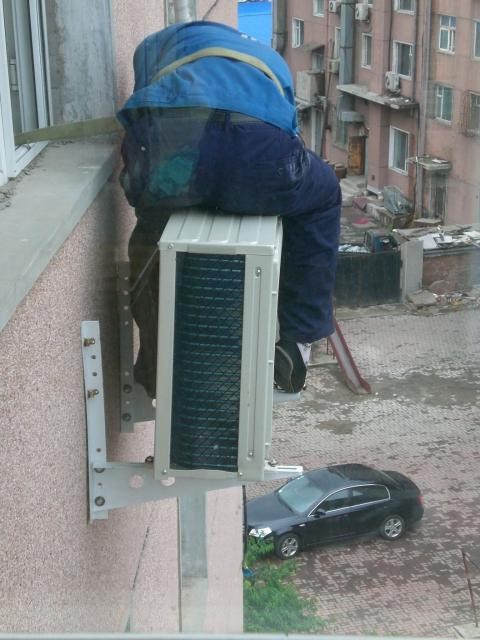 A worker installing air conditioning in my appartment (5th floor). This looks save.